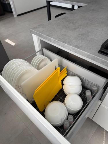 a drawer in a kitchen with plates and utensils at New modern apartments in the centre in Narva