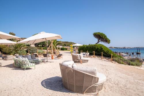 a group of chairs and umbrellas on a beach at Mangia's Sardinia Resort - NEW OPENING in Santa Teresa Gallura