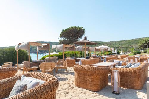 a group of chairs and tables and umbrellas at Mangia's Sardinia Resort - NEW OPENING in Santa Teresa Gallura