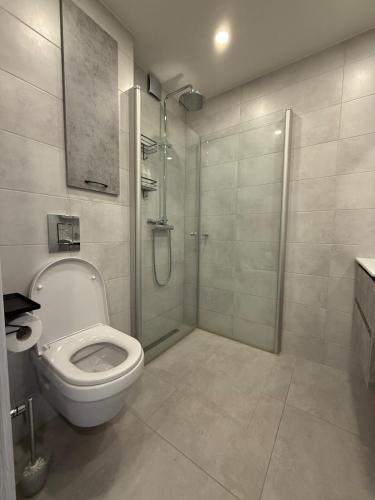a white bathroom with a shower and a toilet at New modern apartments in the centre in Narva