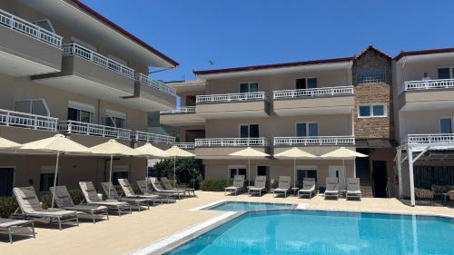 a hotel with a swimming pool and chairs and umbrellas at Sarti Plaza in Sarti