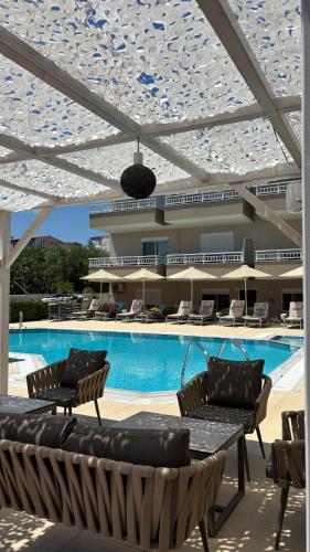 a swimming pool with chairs and a building at Sarti Plaza in Sarti