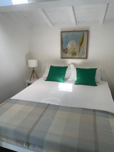 a bedroom with a large white bed with green pillows at Canto del Grillo in Cantagrillo