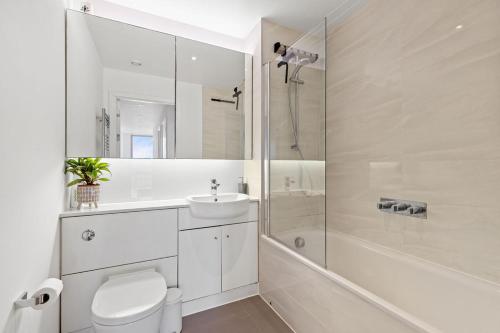 a bathroom with a toilet and a sink and a shower at Luxury Penthouse Stratford City in London