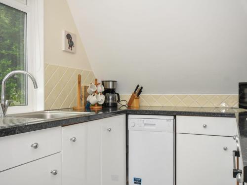 a kitchen with white cabinets and a sink at Valley Lodge 2 in Callington