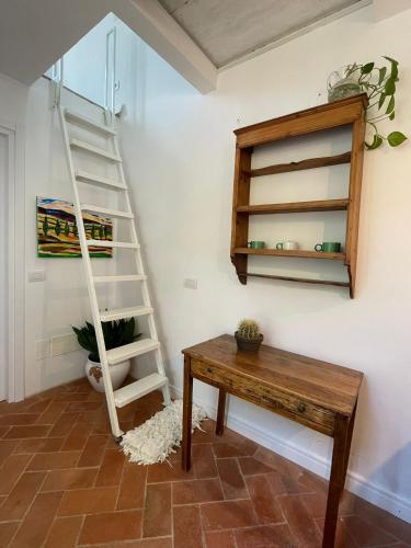 a room with a wooden table and a ladder at Canto del Grillo in Cantagrillo