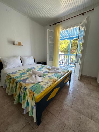a bedroom with a bed and a large window at Galini Hellenic Hospitality in Patitiri