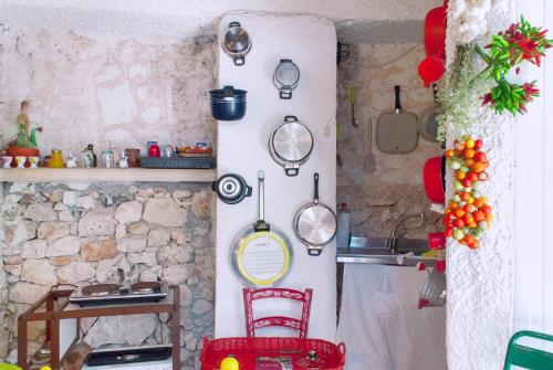 a kitchen with pots and pans on the wall at Limonaia in Salento in Marittima