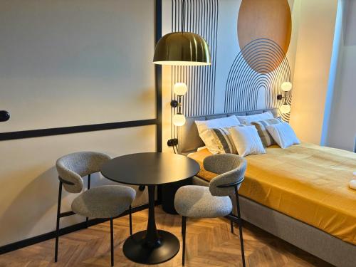 a bedroom with a bed and a table and chairs at ROOSEVELTA RESIDENCE Apartments - przy OFF Piotrkowska in Łódź