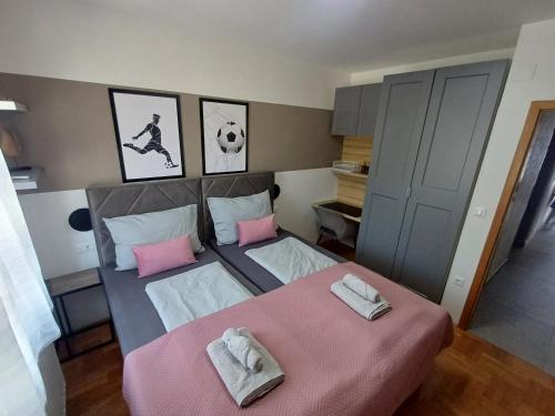 a bedroom with two beds with pink pillows at 16 Čižići in Čižići