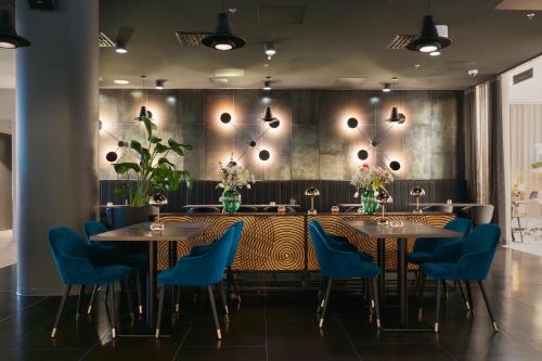 Un comedor con mesas y sillas azules. en Hotel Matts, en Espoo