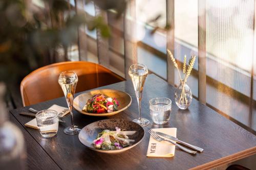 una mesa con dos platos de comida y copas de vino en Hotel Matts, en Espoo