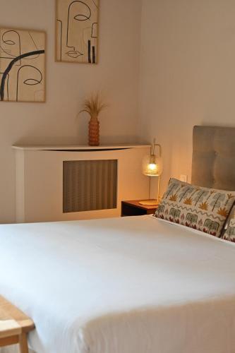 a bedroom with a white bed and a chair at Mas des Comtes de Provence in Tarascon