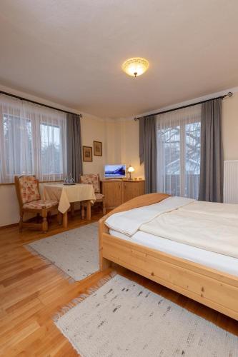 a bedroom with a large bed and a living room at Mörtbauerhof und Haus Frühauf in Seeboden