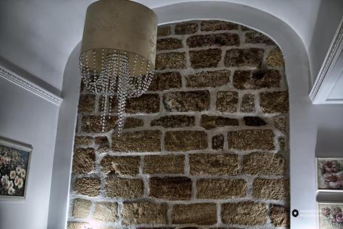 a stone wall with a chandelier hanging from it at TAM Vacanze B&B in Cinisi