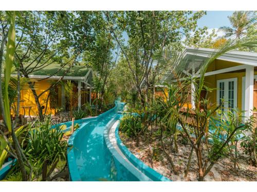 a blue water slide in front of a house at Oaga Art Resort Maldives - Greatest All Inclusive Plan with Free Speedboat Round-trip in North Male Atoll