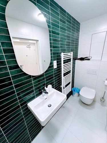 a bathroom with a sink and a mirror and a toilet at Bella Apartments Brno in Brno