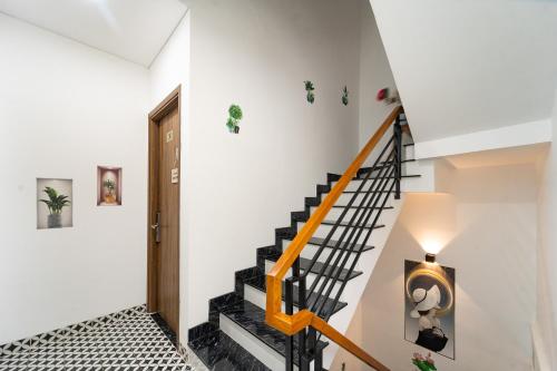 a staircase in a home with white walls and a stair case at Moc Lam Homestay GrandWorld Phu Quoc in Phu Quoc