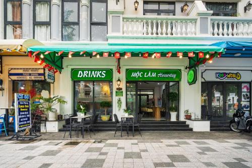 a restaurant with tables and chairs in front of a building at Moc Lam Homestay GrandWorld Phu Quoc in Phu Quoc