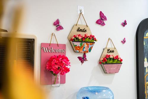a wall with two flower pots and butterflies on it at Moc Lam Homestay GrandWorld Phu Quoc in Phu Quoc