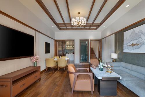 a living room with a couch and a television at The Khyber Himalayan Resort & Spa in Gulmarg