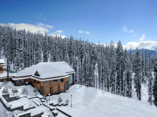 a cabin in the snow with snow covered trees at The Khyber Himalayan Resort & Spa in Gulmarg