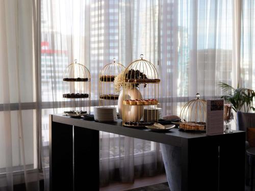 a table with several bird cages filled with food at Mövenpick Hotel Auckland in Auckland