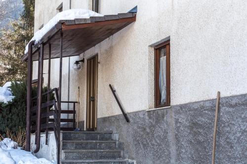 a building with a staircase leading to a door at Relax nel verde in Gravere