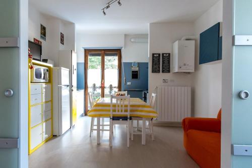 a kitchen with a table and a yellow and white kitchen at Relax nel verde in Gravere