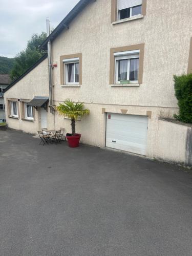 a building with two garage doors and a plant in a pot at Le feuillu Bogny-sur-Meuse in Braux