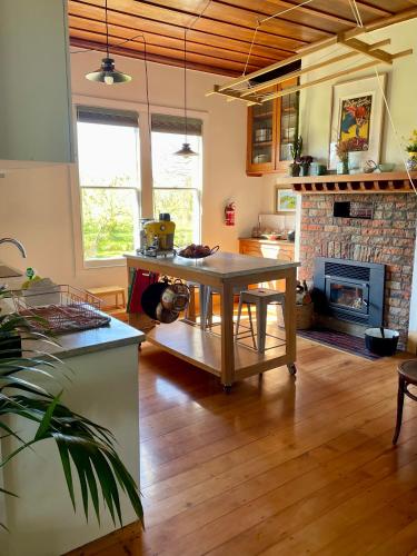a living room with a table and a fireplace at Havelock North Cottage on Organic Orchard in Havelock North