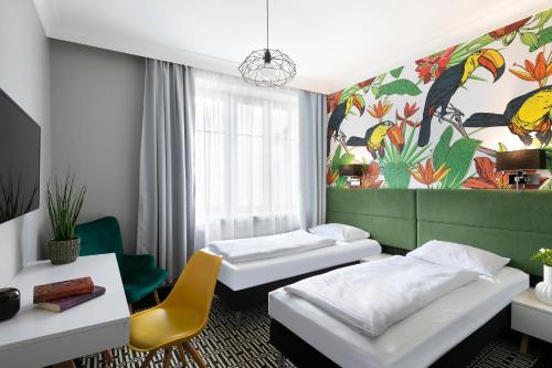 two beds in a room with a painting on the wall at Liv'Inn Aparthotel in Krakow