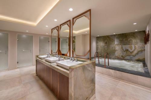 a bathroom with two sinks and a large mirror at The Khyber Himalayan Resort & Spa in Gulmarg
