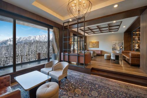 a living room with a view of the mountains at The Khyber Himalayan Resort & Spa in Gulmarg