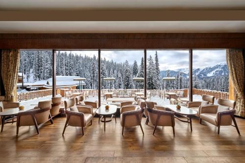 a restaurant with a view of the snow covered mountains at The Khyber Himalayan Resort & Spa in Gulmarg