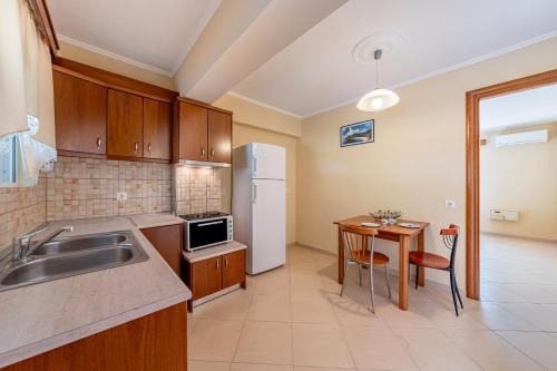 a kitchen with a sink and a table at Alex bar apartments in Sarakiniko