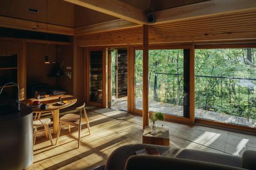 a living room with a table and a large window at SANU 2nd Home 河口湖2nd in Fujikawaguchiko