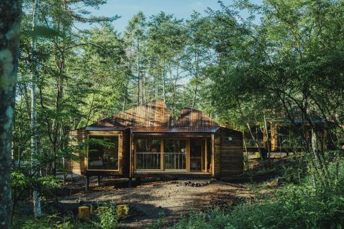 a wooden cabin in the woods with trees at SANU 2nd Home 河口湖2nd in Fujikawaguchiko