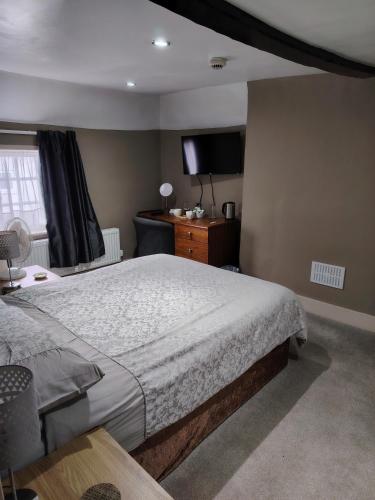 a bedroom with a bed and a television in it at The Wheatsheaf in Salisbury