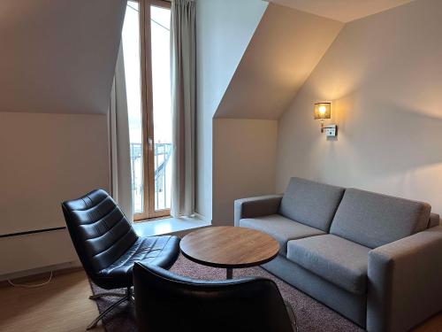 a living room with a couch and a table and chairs at Scandic Parken in Ålesund