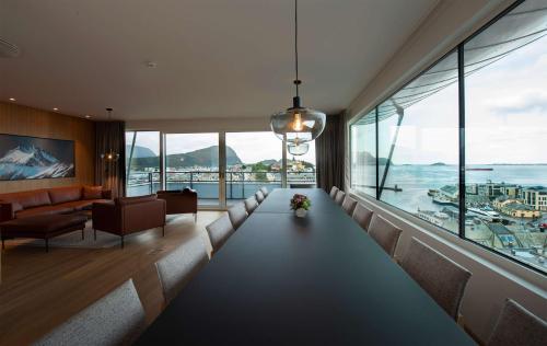 a living room with a long couch and a large window at Scandic Parken in Ålesund