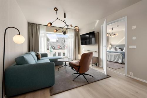 a living room with a blue couch and a table at Scandic Parken in Ålesund