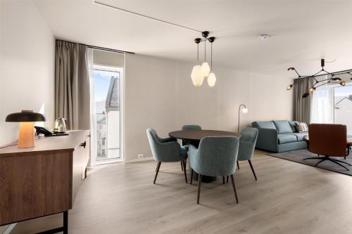 a dining room and living room with a table and chairs at Scandic Parken in Ålesund