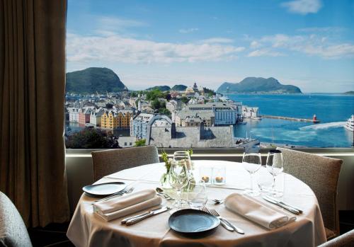 a dining table with a view of the city and the ocean at Scandic Parken in Ålesund