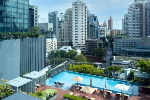a pool on the roof of a building with a city at Radisson Blu Plaza Bangkok in Bangkok