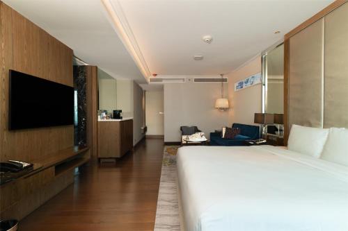 a hotel room with a bed and a flat screen tv at Radisson Blu Plaza Bangkok in Bangkok