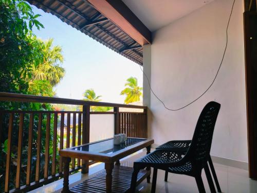a table and chairs on a balcony with a view at Udaya Resort in Palakkad