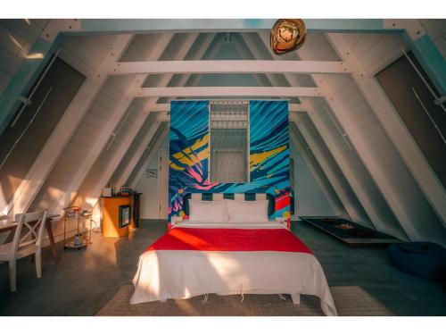a bedroom with a bed with a painting on the wall at Oaga Art Resort Maldives - Greatest All Inclusive Plan with Free Speedboat Round-trip in North Male Atoll