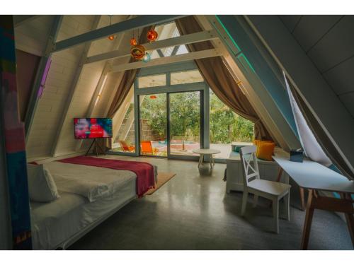 a bedroom with a bed in a room with a window at Oaga Art Resort Maldives - Greatest All Inclusive Plan with Free Speedboat Round-trip in North Male Atoll