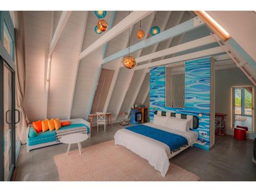 a bedroom with a blue and white bed and a couch at Oaga Art Resort Maldives - Greatest All Inclusive Plan with Free Speedboat Round-trip in North Male Atoll